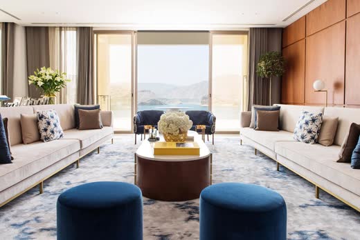 Villa Barr Al Jissah living room, timber panelling, navy velvet and the Gulf of Oman beyond
