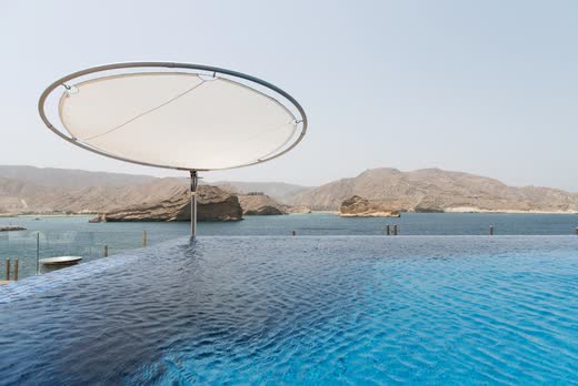 Infinity pool at Villa Barr Al Jissah, mountains and sea beyond