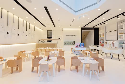 White and the Bear restaurant: pale timber chairs, white tables and a skylight