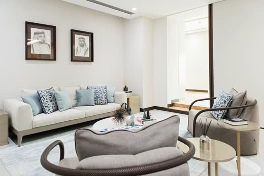 Dubai Holding Chairman Office lounge, soft grey seating around a brass drum table