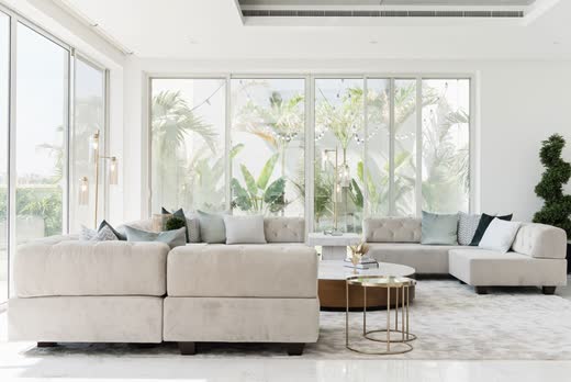 Villa Palm Jumeira I living room, pale sofas and a wall of glass onto the garden